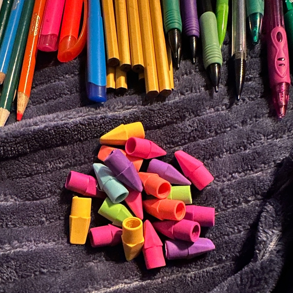 Pencil pouch (with a red stain) with several writing supplies